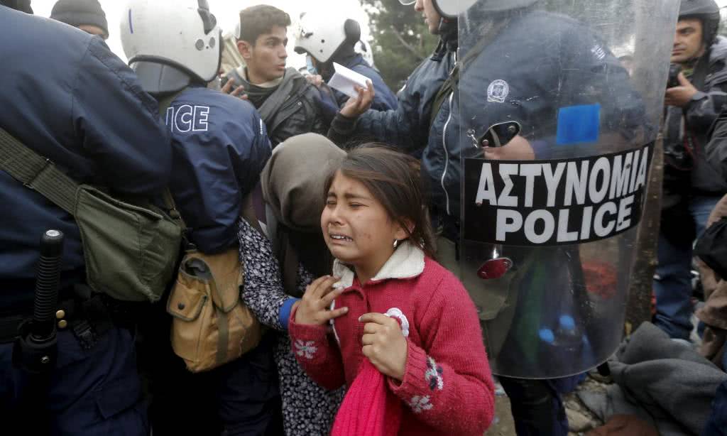 Ένα κορίτσι πρόσφυγας κλαίει αφού έχει μόλις περάσει από τον έλεγχο της αστυνομίας πριν διασχίσει τα σύνορα Ελλάδας Μακεδονίας κοντά στην Ειδομένη, 4 Δεκεμβρίου.