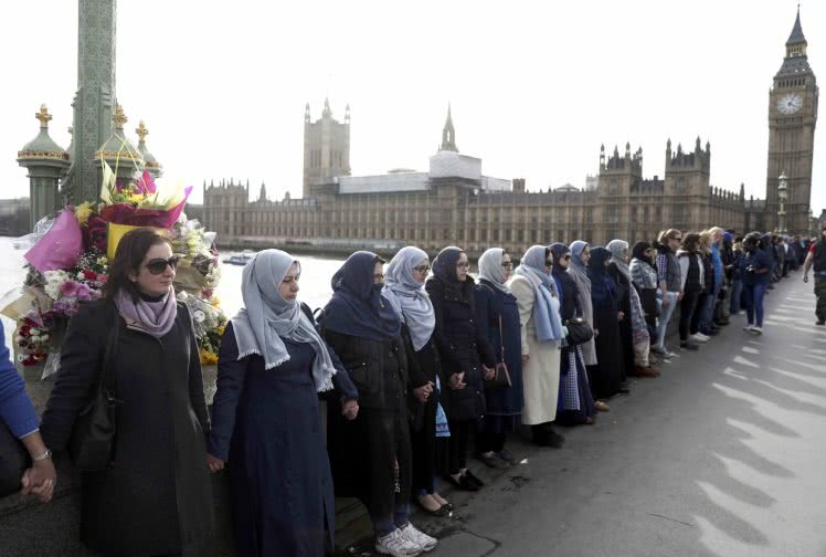 Participants in the Women's March, gather on Westminster Bridge to hold hands in silence, to remember victims of the attack in Westminster earlier in the week, in London